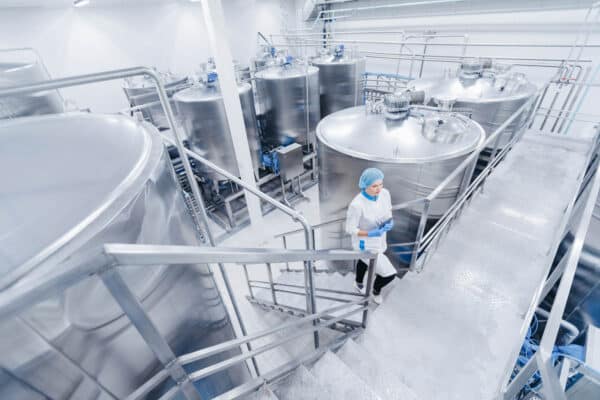 A women in protective gear walks through a food manufacturing plant